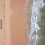 an aerial view of a sandy beach and ocean